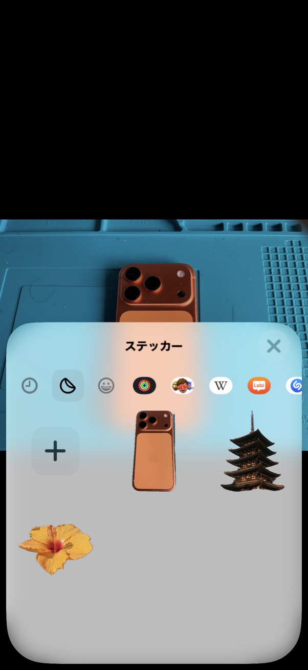スマートフォンの元写真を背景に、スマートフォン・建物・花が並んだステッカー一覧